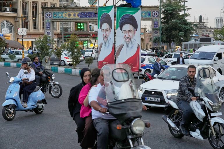 Motorists ride past portraits of Iran's Supreme Leader Mojtaba Khamenei in Tehran, Iran, Wednesday, Oct. 21, 2026.